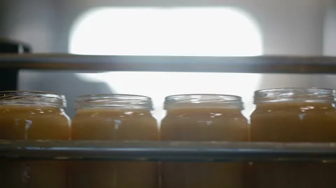Jars with mash move on wide conveyor belt at factory. Video with sound Stock Footage 44866578