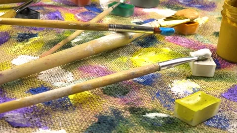 Jars with paints, paint brushes lay out on abstract background  Stock Footage 333569826