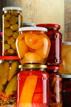 Jars with pickled vegetables, fruity compotes and jams Stock Photos
