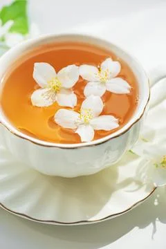 Jasmine tea in white cup with floating flowers Stock Photos