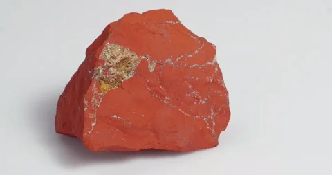 Jastic is red on a white background. Semi-precious ornamental stone. Vídeo Stock 163507345