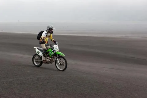 JAVA, INDONESIA - Apr 19, 2015: Tourist riding offroad bike through black a.. 스톡 사진
