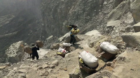 JAVA, INDONESIA - Ijen volcano, worker carrying heavy basket with su Stock Footage 59855873