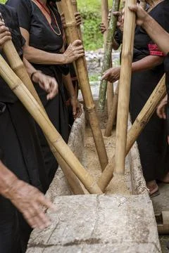 Java, Indonesia, June 13, 2022 - Woman play music while pounding rice in a Fotos Stock