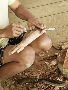 Java, Indonesia, June 13, 2022 - Man carves Tau Tau which are wooden effigies Stock Photos