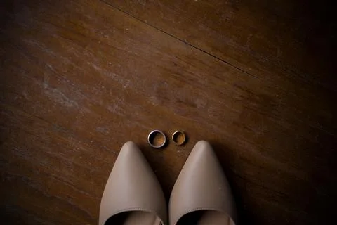 Java wedding closeup attribute with a pair of rings and bridal shoes Stock Photos