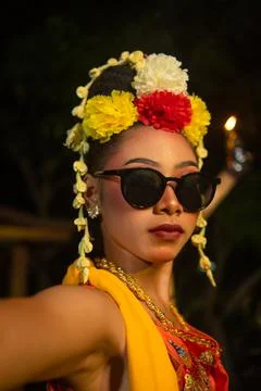 A Javanese dancer dances very skillfully while wearing sunglasses on her ey.. Stock Photos