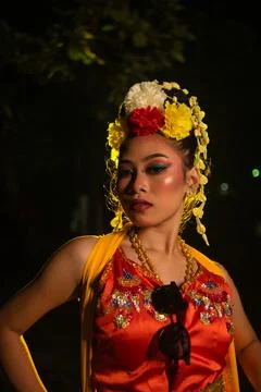 A Javanese dancer poses with sharp eyes and a golden costume on stage Stock Photos