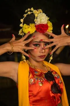 A Javanese dancer poses with sharp eyes and a golden costume on stage Stock Photos