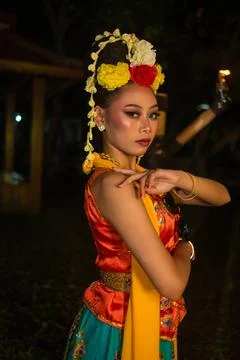 A Javanese dancer poses with sharp eyes and a golden costume on stage Fotos de archivo