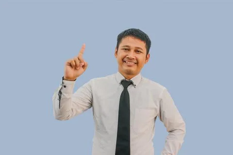 Javanese man smiling happy while pointing finger up Stock Photos