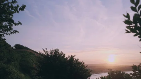 Jaw dropping pull back shot of a sunset through the trees Stock Footage 97084225