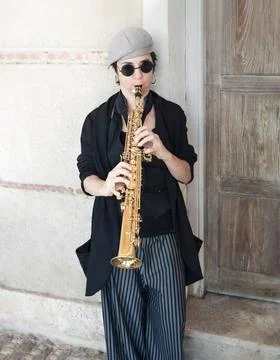 Jazz music dressed in retro style playing saxophone in the street Stock Photos