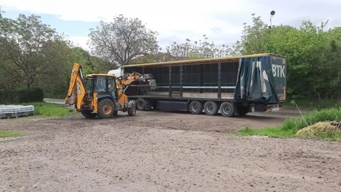 JCB Digger grabs a pack of curbs and moves them to the other packs Vídeo Stock 239559151
