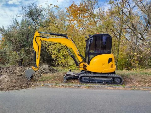 JCB digger or excavator performs excavation work outdoors Stock Photos