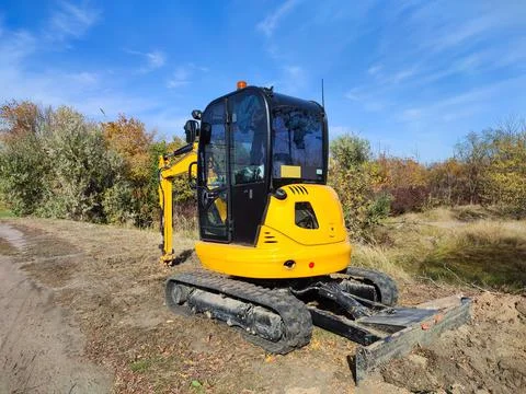 JCB digger or excavator performs excavation work outdoors Stock Photos