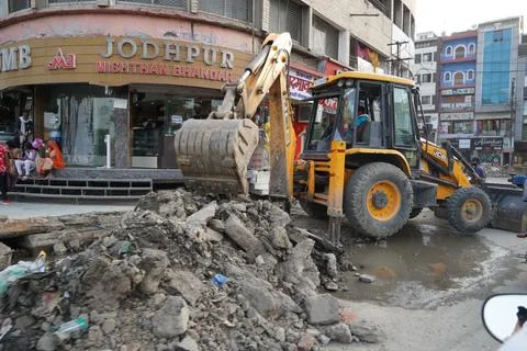JCB earth moving machine working on a road. JCB bucket loader is repairing a Stockfoto's
