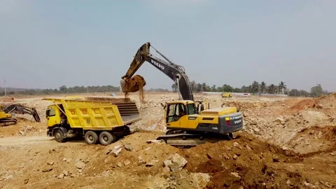 JCB Machine seen digging earth and loading onto a truck at a construction site. Stock Footage 153320097