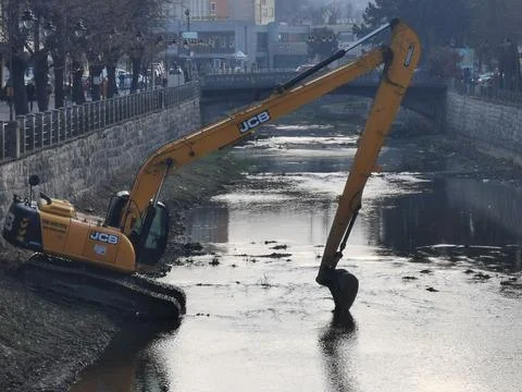 JCB resting in river after long day of work, river cleaning Stock Photos