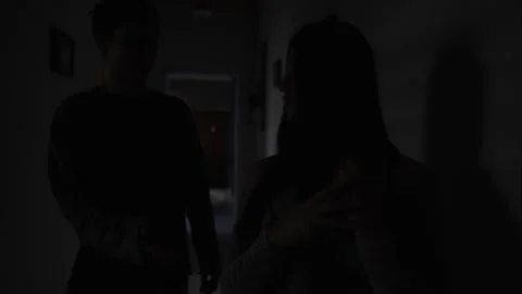 Jealous boyfriend confronting partner about hidden messages in dark hallway Stock Footage 321710784