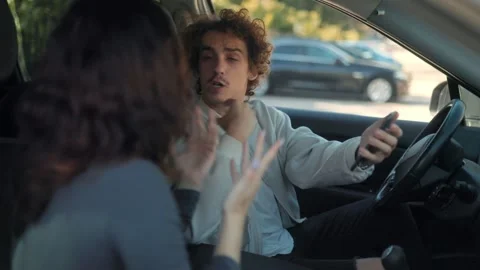 Jealous boyfriend shouting at girlfriend while holding smartphone in car Stock Footage 316456210