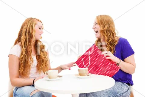 Jealous woman looking at the shopping bag of her happy friend Stock Photos