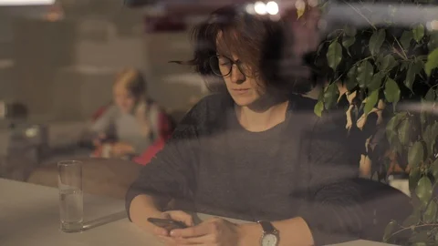 Jealous worried young woman in glasses holding phone feeling jealousy anxiety Stock Footage