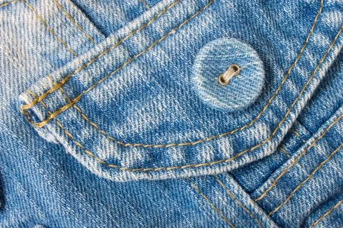 Jeans Button Top Right Corner With Part of Pocket on Pale Blue Jeans Fabric Fotos Stock