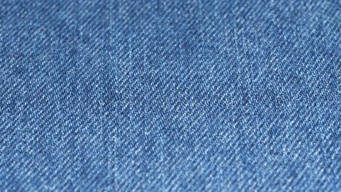 Jeans fabric plain surface, low angle. Shallow DOF, focus at center Stock Footage 121375045
