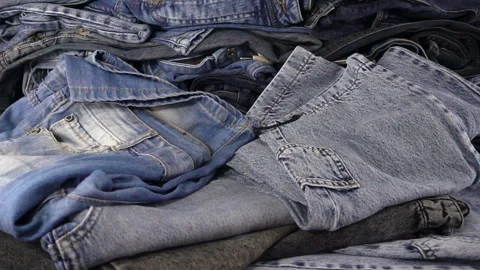 Jeans fall in slow motion on a pile of jeans clothes. Vídeo Stock 130521572