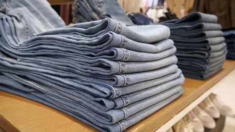 Jeans folded in a stack on the counter Stock Footage 268379956
