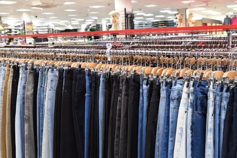 Jeans hanging in a row in a store Stock Photos