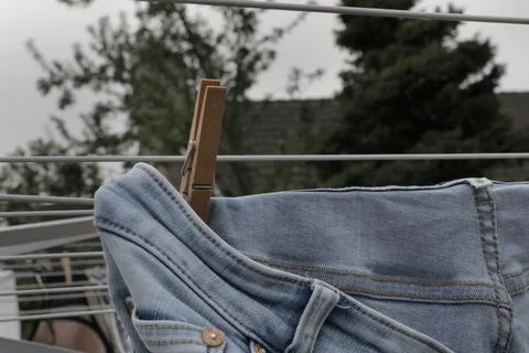 Jeans laundry hanging on a clothesline using a clothespin to dry. Laundry day Stock Photos