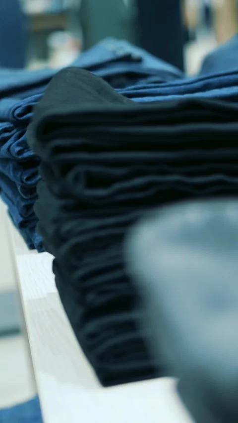 Jeans on a shelf in a store. close-up. Blue jeans of various sizes and models Stock Footage 314658940