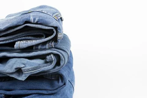 Jeans trousers stack on white background Stock Photos