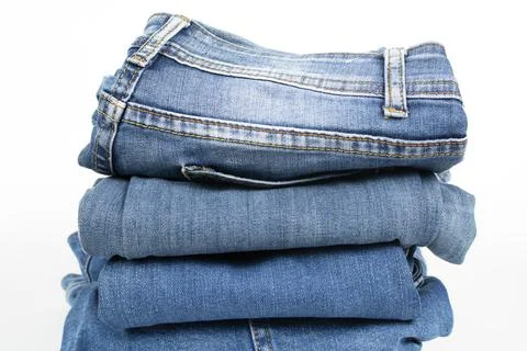 Jeans trousers stack on white background Stock Photos