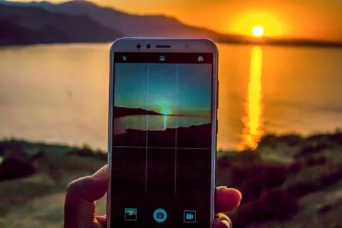 Jebha sunset through smartphone Stock Photos