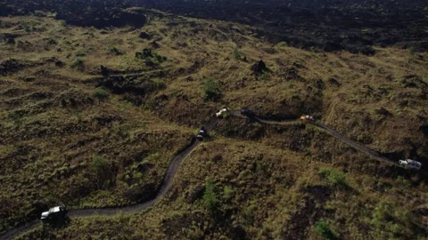 Jeep Convoy Driving to Lava Fields at Mount Batur, Bali – Aerial View Stock Footage 313875015