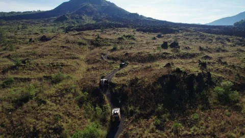 Jeep Convoy Driving to Lava Fields at Mount Batur, Bali – Aerial View Stock Footage 313877750