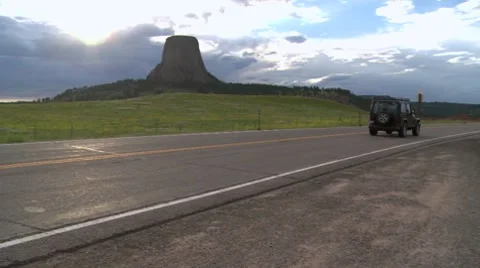 Jeep drives by Devil's Tower National Monument Stock Footage 8537790