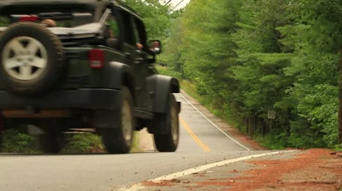 Jeep driving down country road Stock Footage