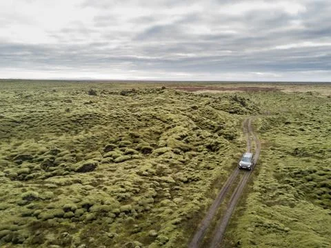 Jeep driving on a road in the moss fields Stock Photos