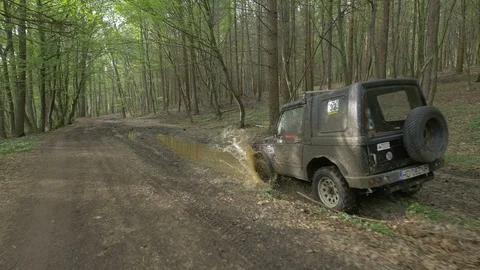 Jeep driving through mud in a forest Stock Footage 87363994
