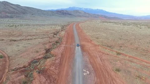 Jeep driving through open desert road into the distance. Stock Footage