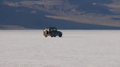 Jeep makes sharp turn while driving in Salt flats Stock Footage 8679698