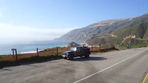 Jeep parking off PCH in Big Sur by Aerial Drone Stock Footage 80963830