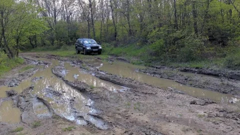 Jeep SUV rides through a huge mud puddle in the forest. Off-road fun Stock Footage 240131759