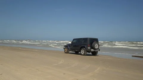 Jeep Wrangler Drives Along Beach Stock Footage