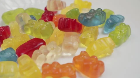 Jelly beans bear shaped colorful candies on a blue background Stock Footage 292628048