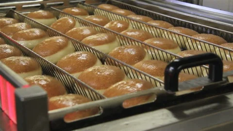 Jelly filled donuts getting fried in a big frying machine Stock Footage 123395872